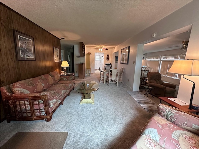 living room with a healthy amount of sunlight, ceiling fan, and a textured ceiling