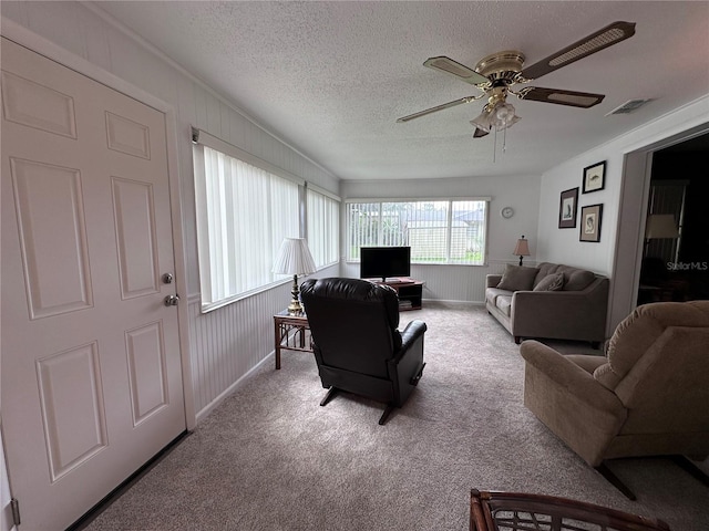 carpeted living room with ceiling fan and a textured ceiling