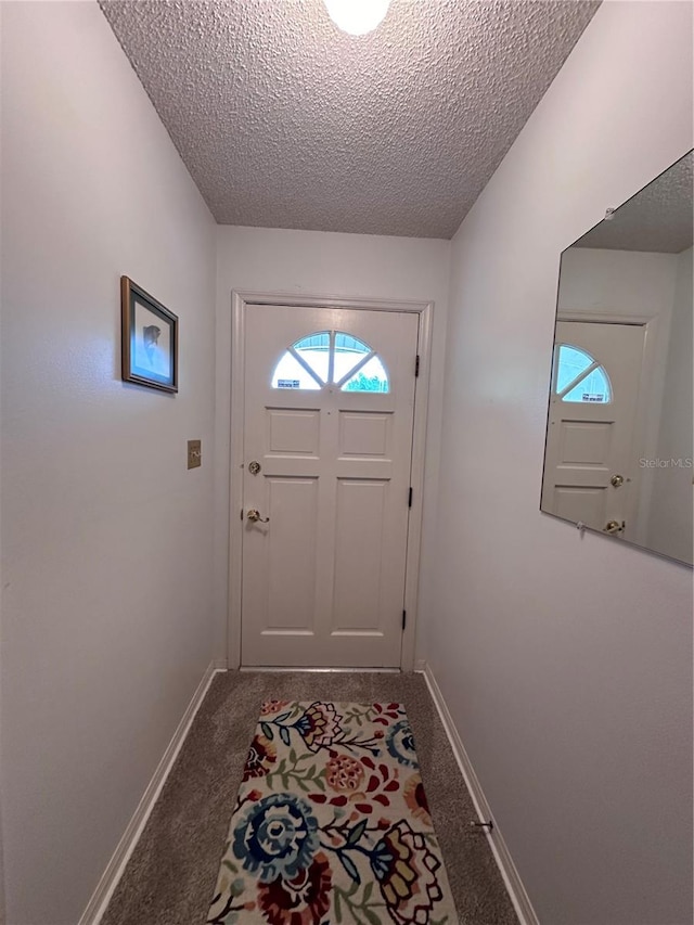 entryway featuring a textured ceiling and carpet floors