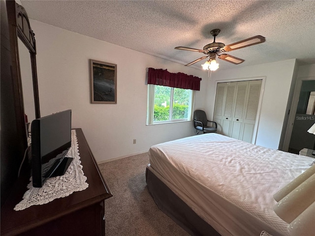 bedroom with a textured ceiling, ceiling fan, a closet, and carpet floors