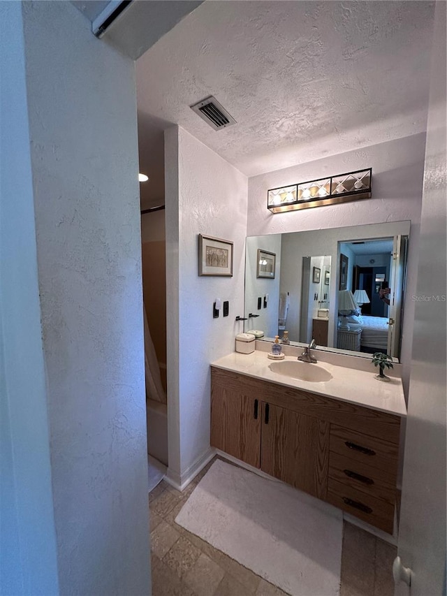 bathroom with a textured ceiling and vanity