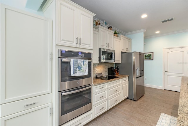 kitchen with ornamental molding, light hardwood / wood-style flooring, backsplash, white cabinetry, and stainless steel appliances