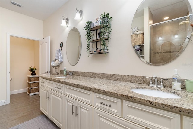 bathroom featuring walk in shower, hardwood / wood-style flooring, and vanity