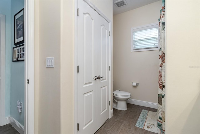 bathroom with toilet and hardwood / wood-style flooring