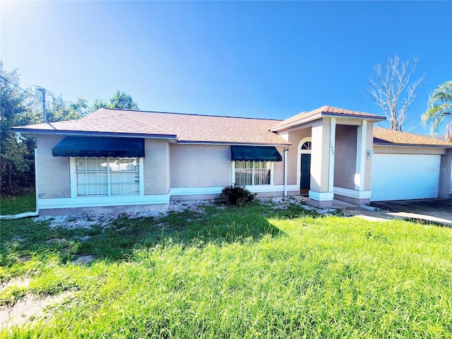 ranch-style home featuring a garage and a front lawn