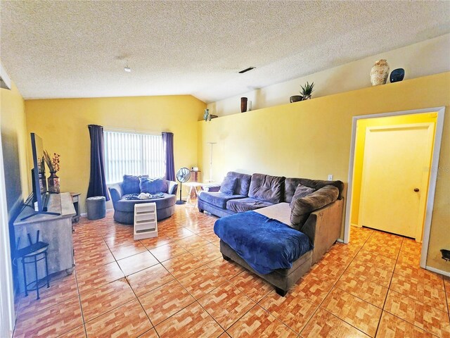 tiled living room with a textured ceiling and vaulted ceiling