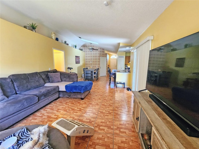 living room with a textured ceiling, ceiling fan, and tile patterned floors