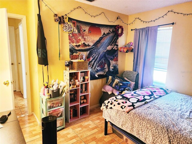 bedroom with a textured ceiling, hardwood / wood-style floors, and multiple windows