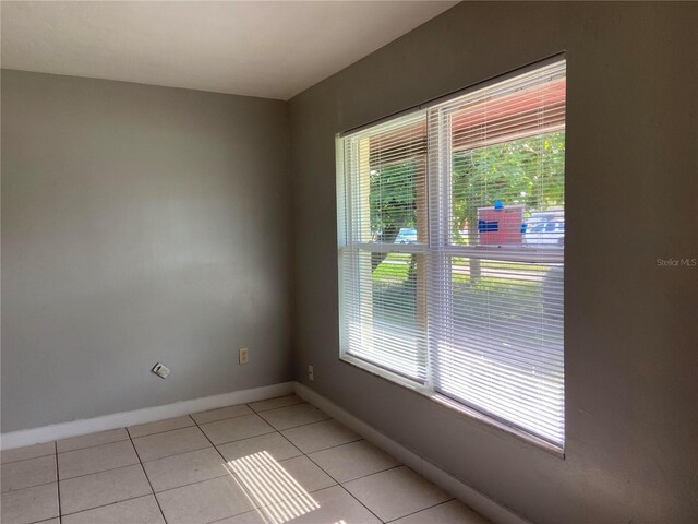 tiled empty room with a wealth of natural light