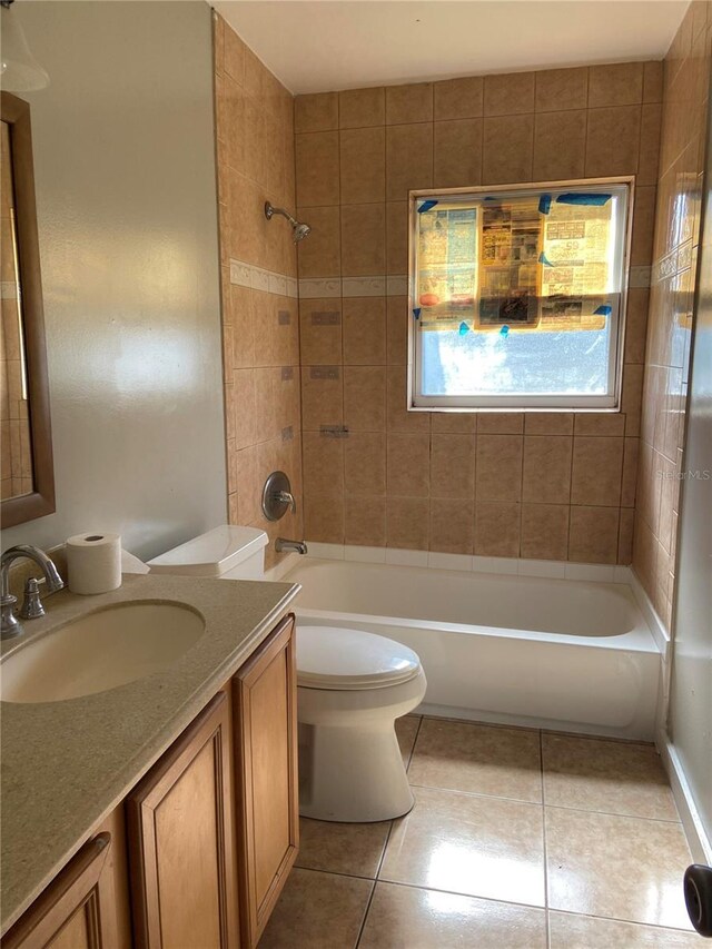 full bathroom with tile patterned floors, toilet, tiled shower / bath combo, and vanity