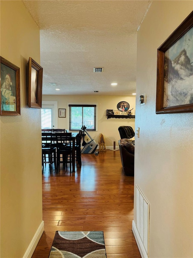 dining space with a textured ceiling and dark wood-type flooring