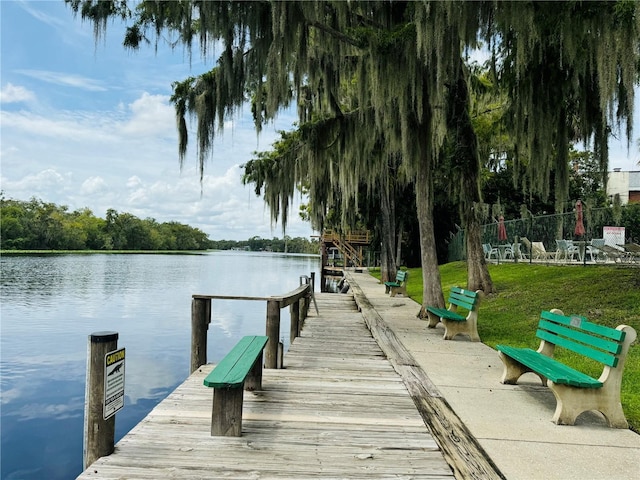 dock area featuring a lawn and a water view