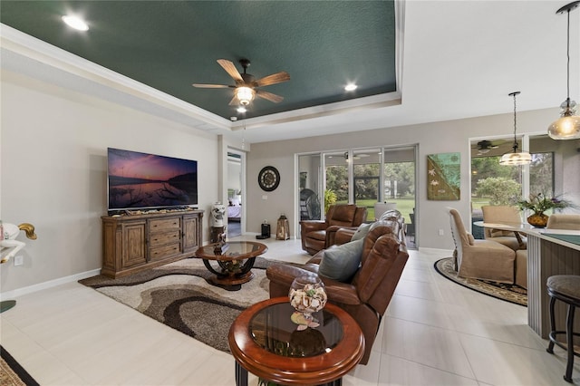 tiled living room featuring a textured ceiling, a raised ceiling, and ceiling fan