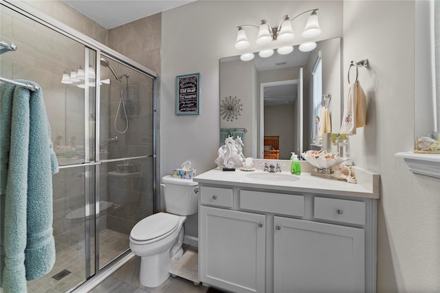 bathroom with tile patterned flooring, toilet, a shower with door, and vanity