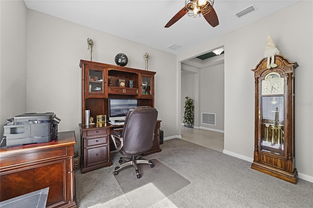 carpeted office space with ceiling fan