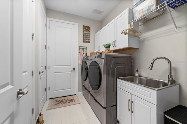 washroom featuring cabinets, washer and clothes dryer, and sink