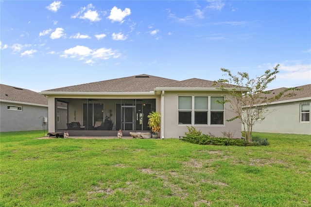 rear view of property featuring a sunroom and a lawn