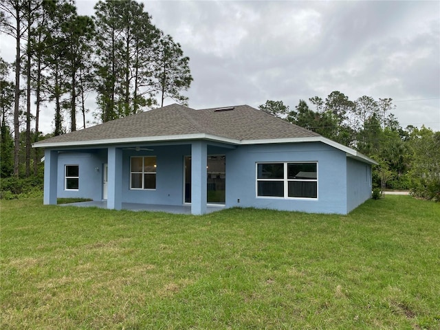 back of property with a lawn and ceiling fan