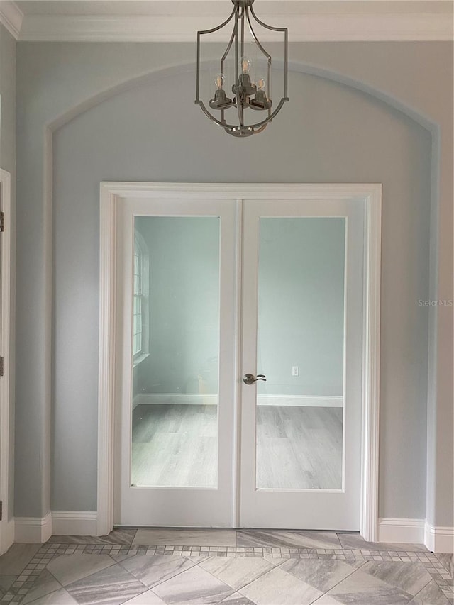 doorway to outside featuring ornamental molding, a notable chandelier, and french doors