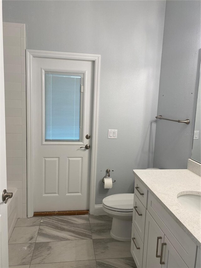 bathroom featuring vanity, toilet, and a bathing tub