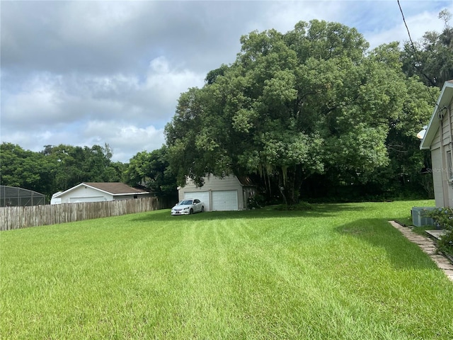 view of yard with cooling unit, fence, and an outdoor structure