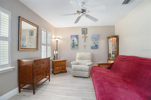 living room featuring a healthy amount of sunlight, ceiling fan, and light hardwood / wood-style floors