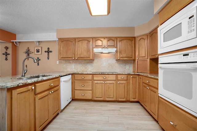 kitchen with a textured ceiling, kitchen peninsula, sink, and white appliances