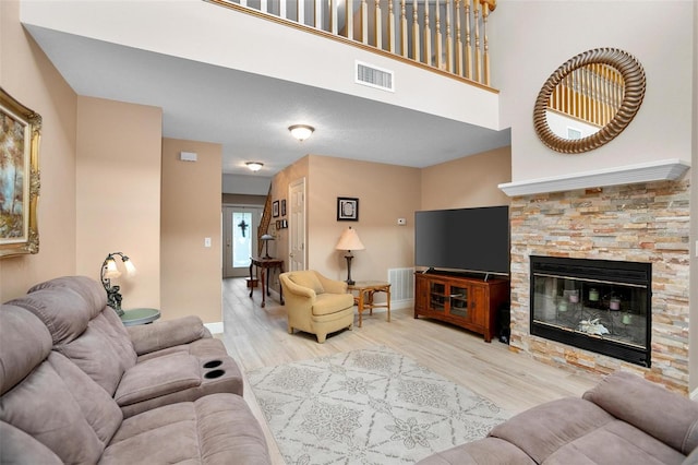 living room with a stone fireplace and light hardwood / wood-style floors