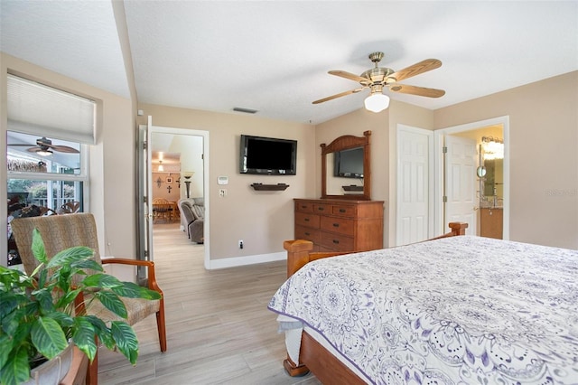 bedroom with ceiling fan, connected bathroom, a textured ceiling, and light hardwood / wood-style flooring