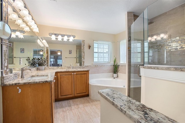 bathroom with shower with separate bathtub and vanity