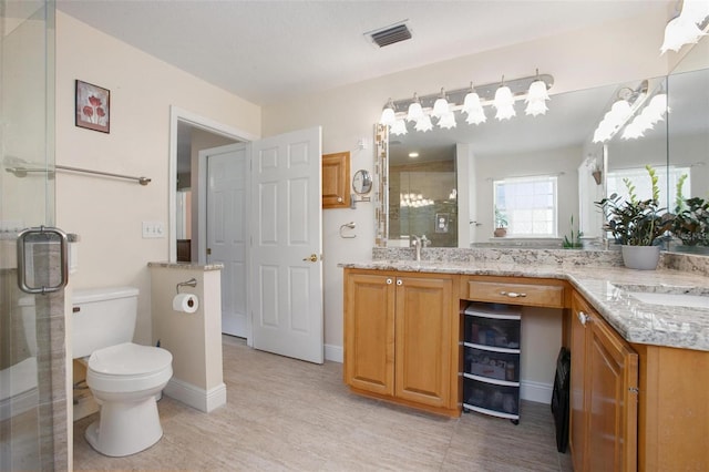 bathroom with vanity, toilet, and a shower with door