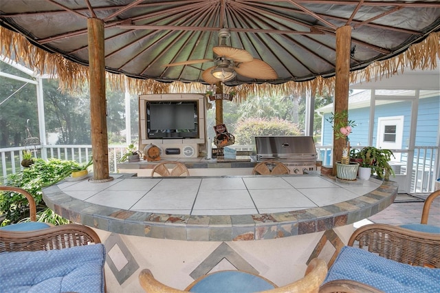 view of patio with exterior bar, a gazebo, area for grilling, ceiling fan, and grilling area