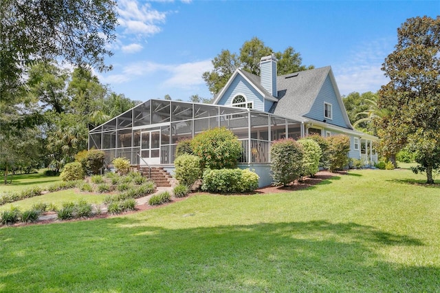 back of house featuring glass enclosure and a lawn