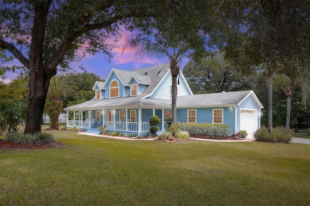 view of front of house featuring a garage, a yard, and covered porch