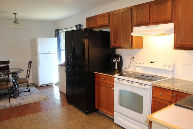 kitchen with pendant lighting, white appliances, and light hardwood / wood-style floors