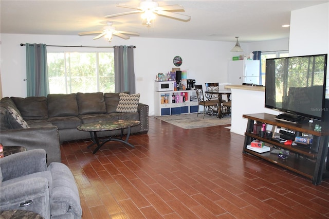 living room featuring ceiling fan and dark hardwood / wood-style floors