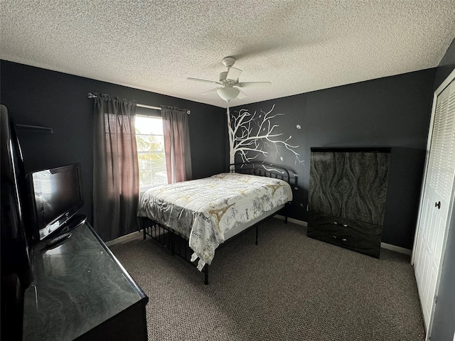 bedroom with ceiling fan, baseboards, carpet floors, and a textured ceiling