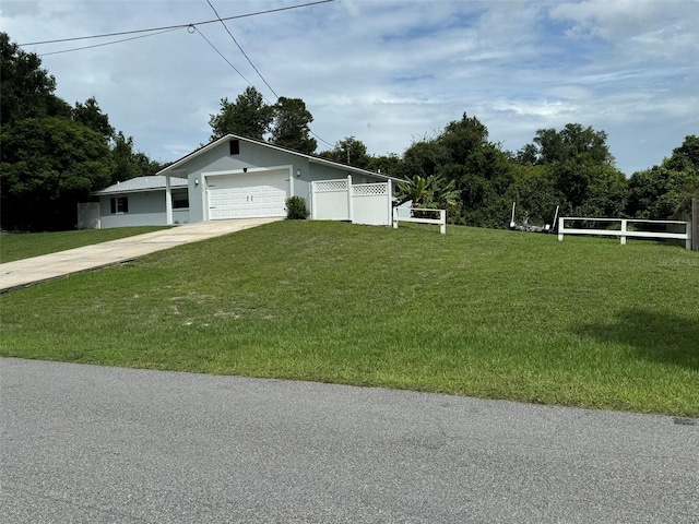 view of front of house with stucco siding, driveway, fence, a front yard, and an attached garage