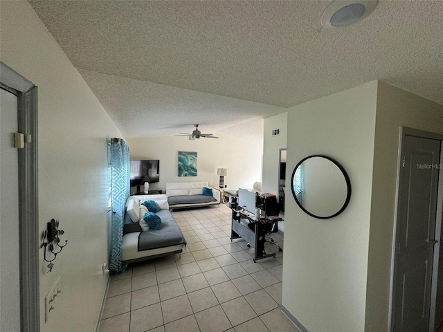 living room with a textured ceiling, vaulted ceiling, light tile patterned floors, and ceiling fan