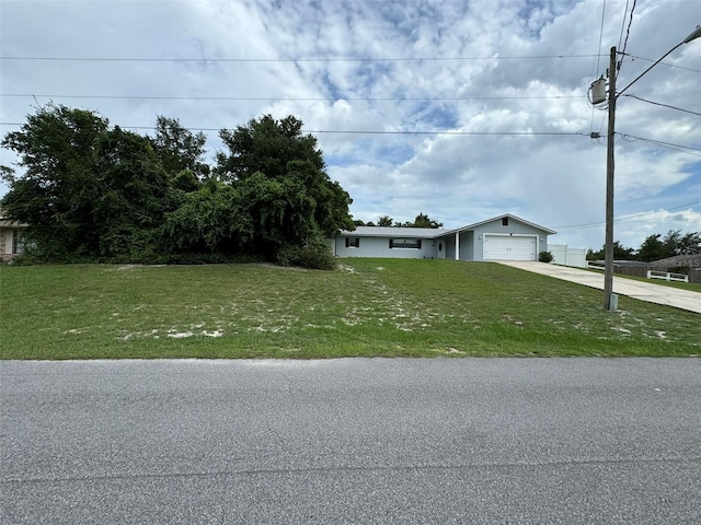 view of front of home with a garage, concrete driveway, and a front yard