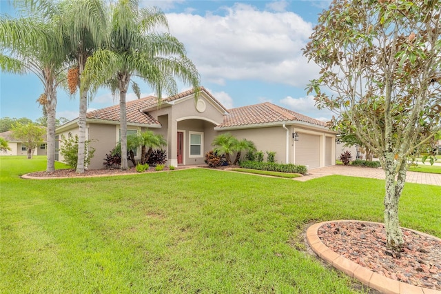 mediterranean / spanish-style house with a garage and a front lawn