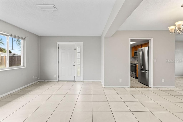 tiled empty room with a notable chandelier