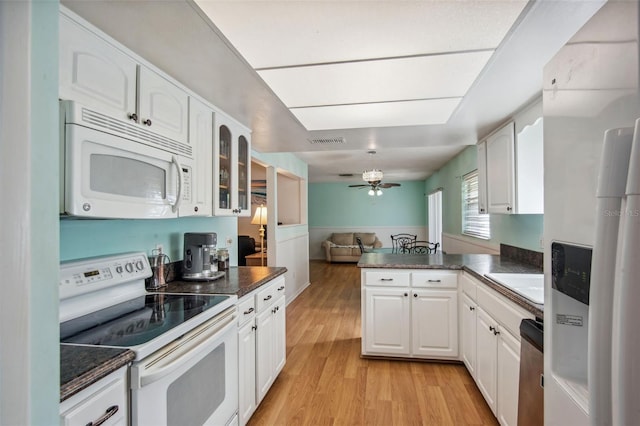 kitchen featuring white appliances, kitchen peninsula, white cabinetry, ceiling fan, and light wood-type flooring