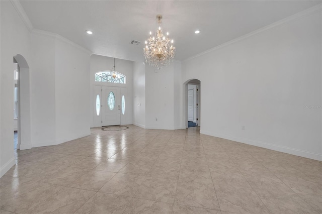 spare room with ornamental molding and an inviting chandelier