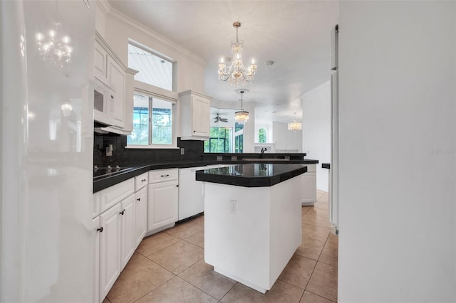 kitchen featuring white appliances, a chandelier, a kitchen island, hanging light fixtures, and white cabinets