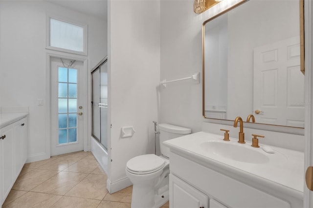 full bathroom with combined bath / shower with glass door, vanity, toilet, and tile patterned floors