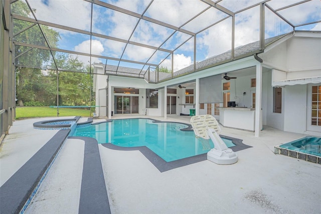 view of pool featuring glass enclosure, a patio, and ceiling fan