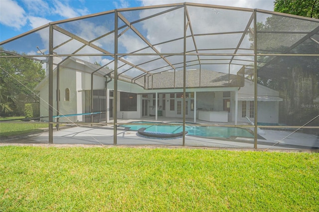 view of pool featuring glass enclosure, a lawn, and a patio