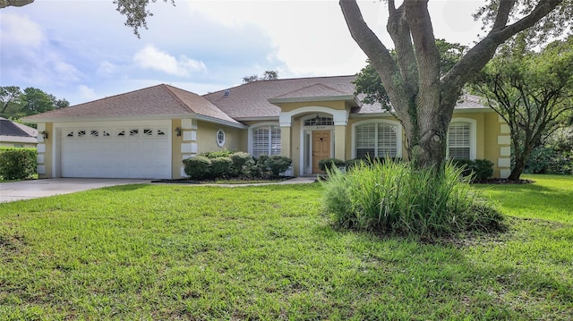 view of front facade with stucco siding, driveway, a garage, and a front lawn