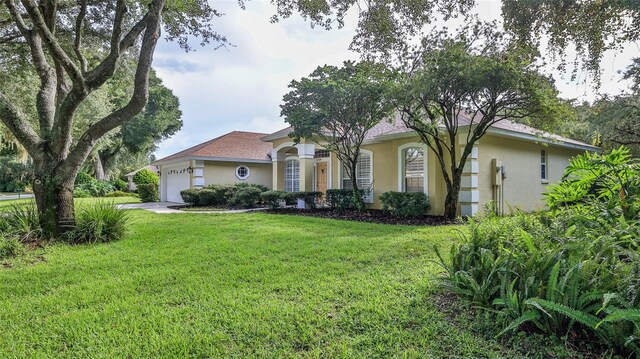 view of front of house featuring a garage and a front lawn